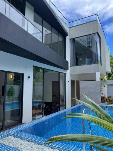 a house with a swimming pool in front of it at Unwind Dhigurah in Dhigurah