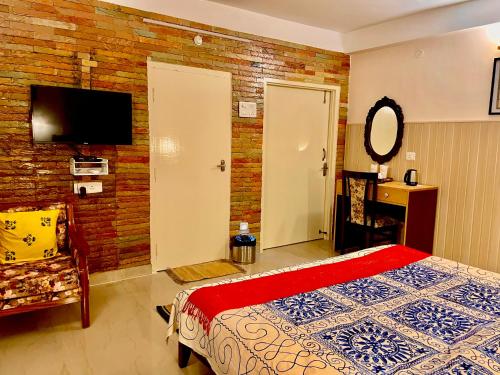 a bedroom with a bed and a brick wall at Bougainvillea in Guwahati