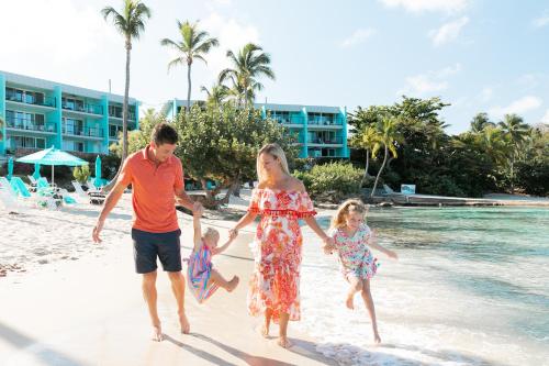 a family is walking on the beach at Secret Harbour Beach Resort in St Thomas
