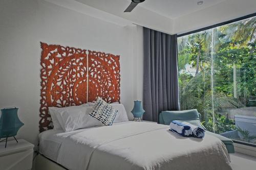 a bedroom with a large bed with a large window at Unwind Dhigurah in Dhigurah