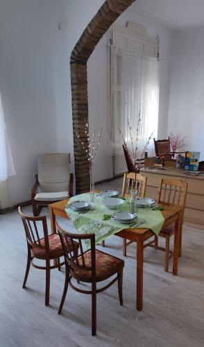a table and chairs in a living room with a table and chairsktop at Szorcsik Ház 1913 in Senta