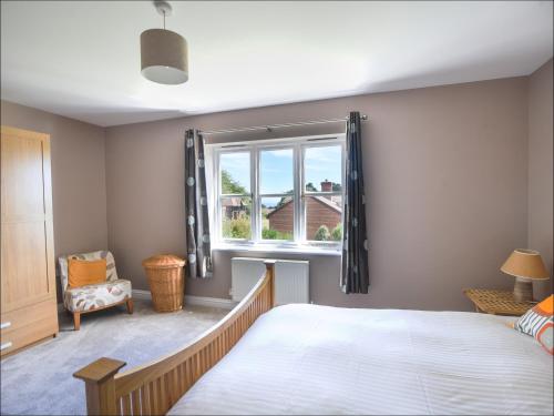sypialnia z dużym łóżkiem i oknem w obiekcie 12 The Gardens w mieście Lyme Regis