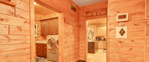 a log cabin kitchen with a washer and dryer at Edelweiss Lodge in Boyne Falls