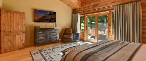 a bedroom with a bed and a large window at Edelweiss Lodge in Boyne Falls