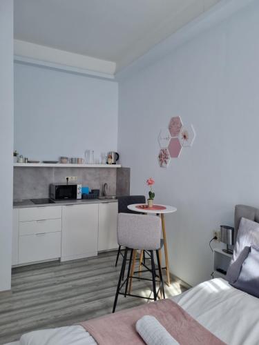 a room with a bed and a table and a kitchen at Eden City Home in Győr