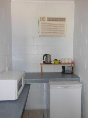 a kitchen with a microwave and a counter with a appliance at Country Road Motel in Charters Towers
