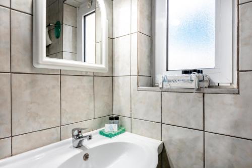 bagno con lavandino e specchio di Aroni Cretan comfortable house - Hamam suites Aroni a Arónion