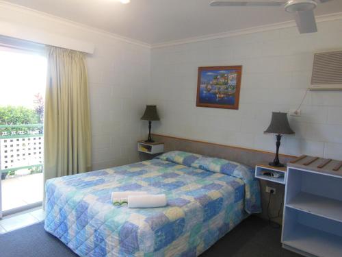 a hotel room with a bed and a window at Country Road Motel in Charters Towers
