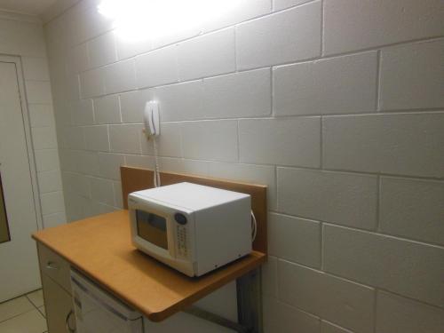 a white microwave sitting on top of a wooden table at Country Road Motel in Charters Towers