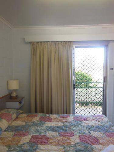 a bedroom with a bed and a large window at Country Road Motel in Charters Towers