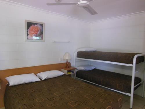 a room with two bunk beds and a table at Country Road Motel in Charters Towers