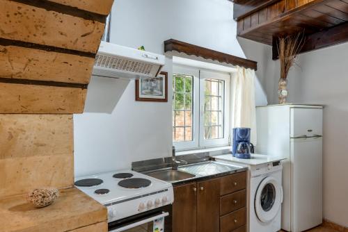 a kitchen with a stove and a sink and a refrigerator at Aroni Cretan comfortable house - Hamam suites Aroni in Arónion
