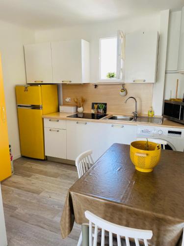 - une cuisine avec une table et un bol jaune dans l'établissement Nid douillet sur la Côte d'Azur, à Antibes