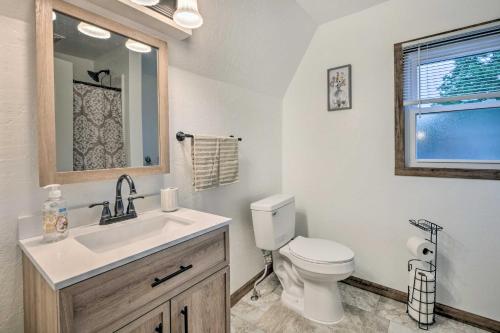 a bathroom with a toilet and a sink and a window at The Shady Cottage Millersburg Getaway with Deck in Millersburg