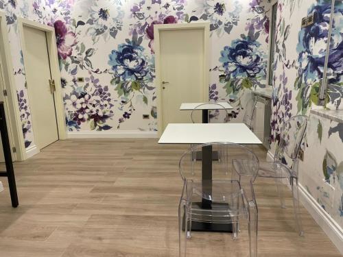 a dining room with purple and blue floral wallpaper at B&B The Garden in Pescara