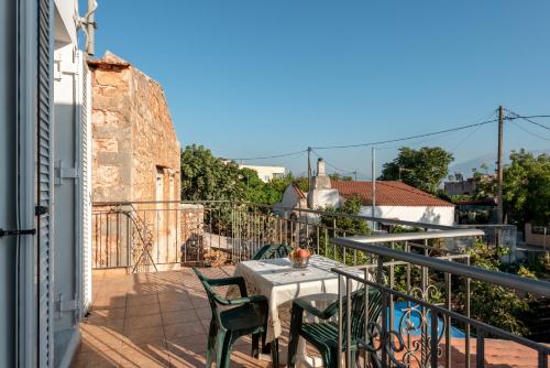 a patio with a table and chairs on a balcony at Aroni Cretan comfortable house - Hamam suites Aroni in Arónion