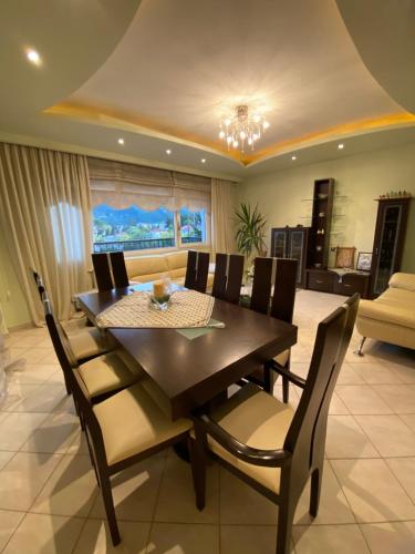 een eetkamer met een houten tafel en stoelen bij Florina House - Spacious with 2 Bedrooms and mountain view in Florina