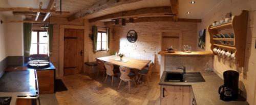 a kitchen with a wooden table and chairs in a room at Vorderkaseralm in Sankt Johann im Pongau