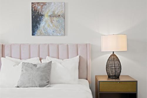a bedroom with a bed with a lamp on a night stand at Placemakr Music Row - Vanderbilt in Nashville