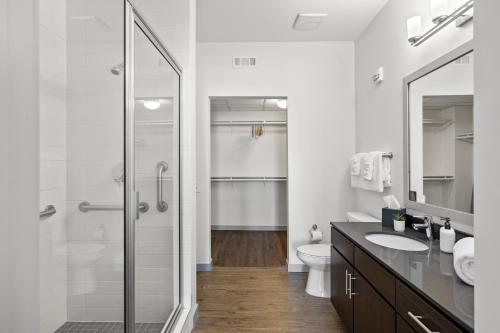 a bathroom with a shower and a toilet and a sink at Placemakr Music Row - Vanderbilt in Nashville