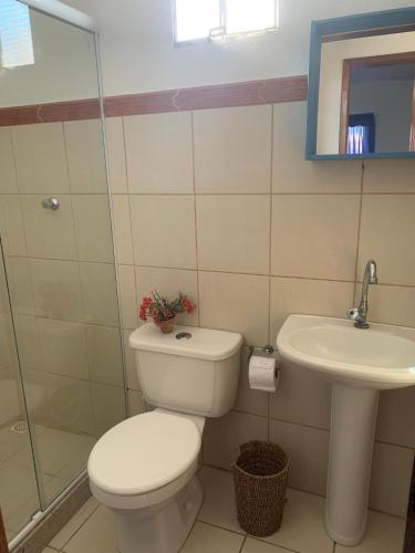 a bathroom with a toilet and a sink at Chalé beira mar Jacaraipe in Serra