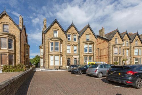 a row of buildings with cars parked in front of them at Ashton Mews apartment with free parking in Saint Annes on the Sea