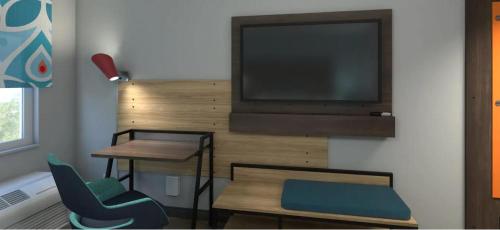 a living room with a tv and a table and chairs at Tru By Hilton Manteca in Manteca