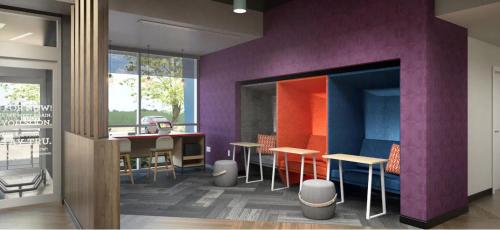 a restaurant with purple walls and tables and chairs at Tru By Hilton Manteca in Manteca