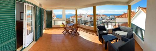 a balcony with chairs and a view of the ocean at Villa Kethellen in Porto Covo