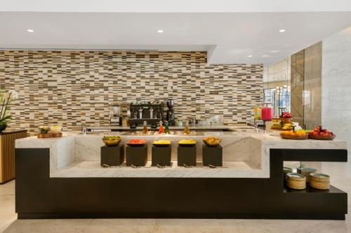 a kitchen with a counter with fruits and vegetables at Wyndham Grand Doha West Bay Beach in Doha