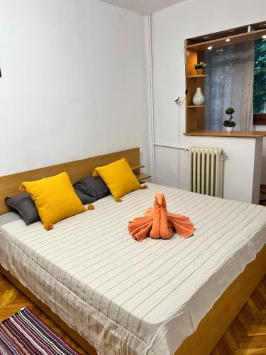 una cama con un animal de peluche naranja en ella en Miha modern and central apartament Malul Mureșului en Arad