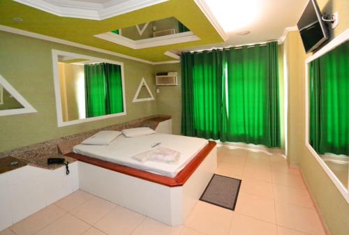 um quarto com cortinas verdes e uma cama em Caravellas Hotel no Rio de Janeiro