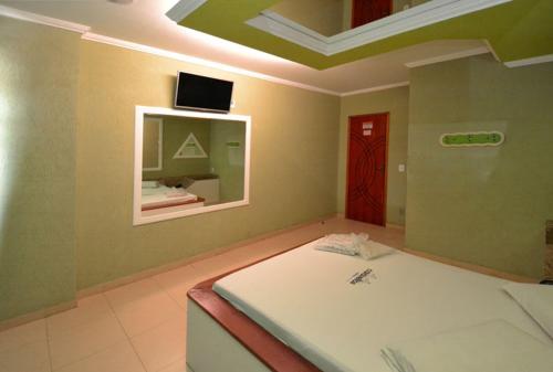 um quarto com uma cama e uma televisão no tecto em Caravellas Hotel no Rio de Janeiro