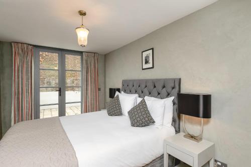 een slaapkamer met een groot wit bed en een raam bij PenthouseStays nr Notting Hill - Luxury 2 Bedroom King Bed Apartment - near Portobello Road in Londen