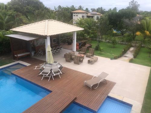een patio met een terras en een zwembad bij Quintas de Sauipe, Casa F7 in Costa do Sauipe