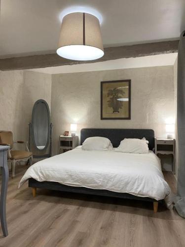 une chambre avec un grand lit blanc et une lampe dans l'établissement La Maison Du Parc RDC, à Balaruc-les-Bains