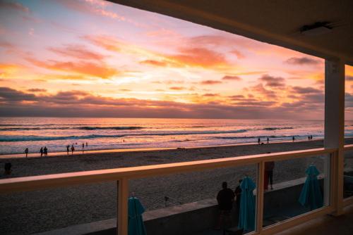 a view of the beach at sunset from a balcony at Del Mar Beach Hotel in San Diego