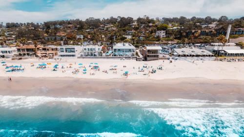 an aerial view of a beach with people and the ocean at Del Mar Beach Hotel in San Diego
