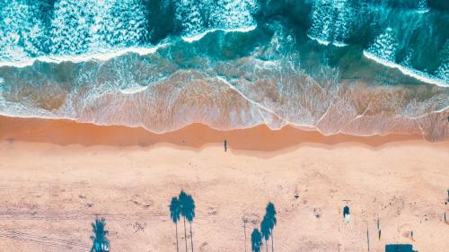 an overhead view of a beach with people walking on the sand at Del Mar Beach Hotel in San Diego