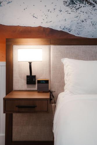 a bedroom with a bed and a lamp on a night stand at Del Mar Beach Hotel in San Diego