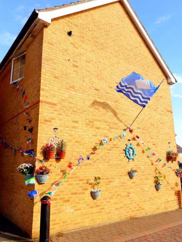 a brick building with flags and plants on it at Marina & Seagulls in East Cowes