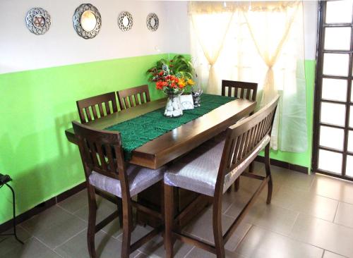 a dining room table with chairs and a green wall at Céntrico loft Boho chic con terraza, Wifi, cocina in Texcoco de Mora