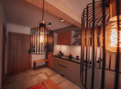 a kitchen with a chandelier in the middle of a room at ARLhome - Zuhause am Arlberg in Sankt Anton am Arlberg