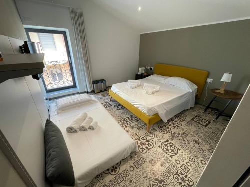 a hotel room with two beds and a window at Gaias Rooms in Olbia