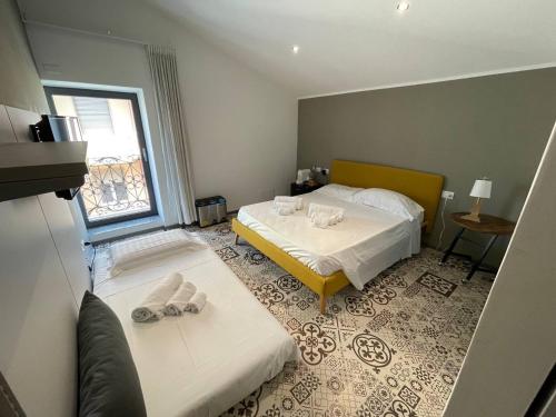 1 Schlafzimmer mit 2 Betten und einem Fenster in der Unterkunft Gaias Rooms in Olbia
