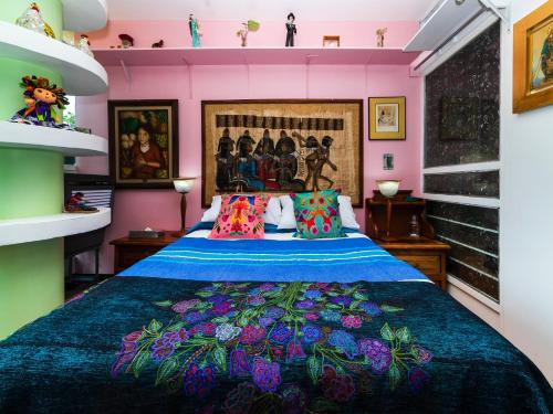 a bedroom with a bed with a blue comforter at Casa Itzae B&B Polanquito Dog Friendly in Mexico City