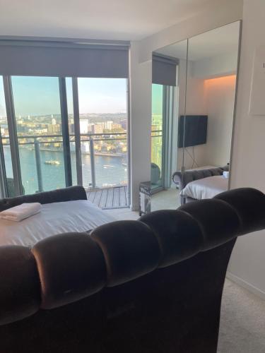 a bedroom with a couch and a view of the water at off 13 in London
