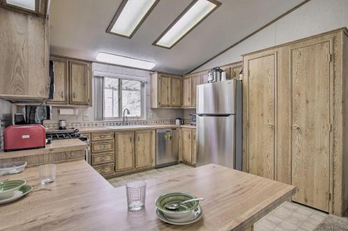 a kitchen with wooden cabinets and a stainless steel refrigerator at Family-Friendly Home about 1 Mi to Kern River! in Wofford Heights