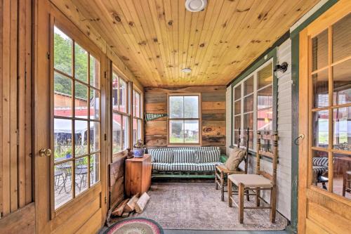 een woonkamer met een bank en ramen bij Rustic Roxbury Ski Farmhouse with Trails! in Roxbury