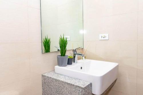 a bathroom with a white sink and a mirror at Holiday suite at Uptown Parksuites II Uptown BGC in Manila